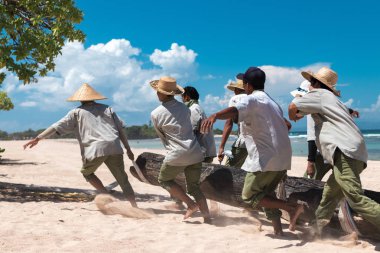 Bali, Endonezya - 26 Nisan 2017: büyük bir ağaç Endonezya Bali Adası'getirdiğin Paradise beach işçi.