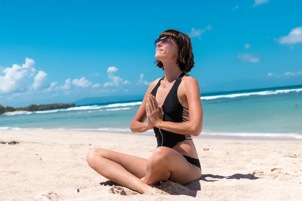 Yoga en la playa del mar o del océano. Chica meditando en pose de loto en la isla tropical de Bali, Indonesia.. Estilo de vida saludable. Meditación de la mañana.Yoga concepto de meditación. Mujer joven practicando yoga — Foto de Stock