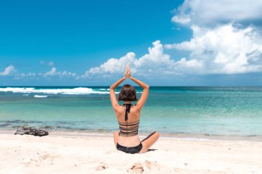 Pratik Yoga plajda Nusa Dua, tropikal Bali Adası, Endonezya genç sağlıklı çekici kadın. Metin için boş alan.