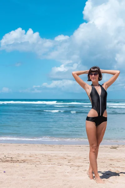 Vacances à la plage. Femme heureuse profitant d'une journée ensoleillée à la plage. Les bras ouverts, la liberté, le bonheur et la félicité. Concept tropical, Bali île . — Photo
