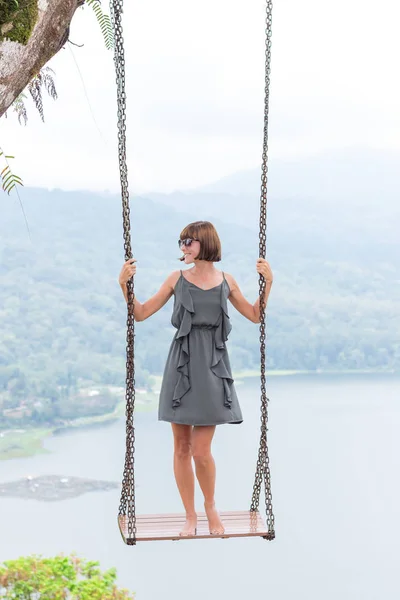 Sexy young aldy swinging over the precipice on the magic tropical Bali island, Indonesia. — Stock Photo, Image