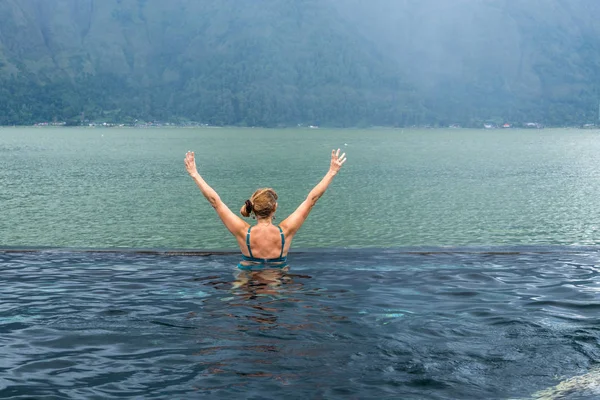 Vezető nő a természet medence csodálatos hegyi hátteret. Trópusi sziget, Bali, Indonézia. — Stock Fotó
