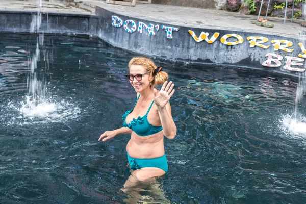 Senior vrouw in de natuur Thermae zwembad. Tropische eiland Bali, Indonesië. — Stockfoto