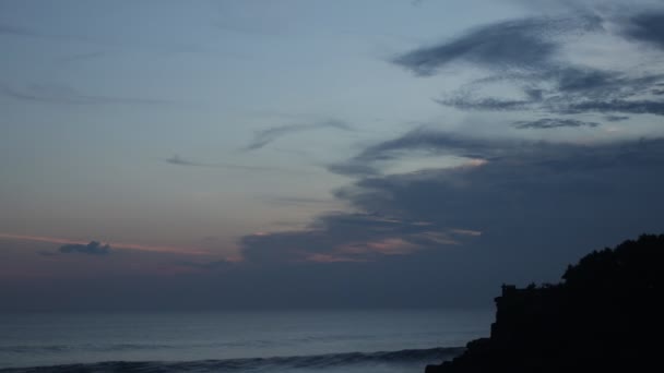 美丽海海岸岩石峭壁日落海滩波浪破碎的太阳照耀度假，美丽夏天概念。印度尼西亚巴厘岛. — 图库视频影像