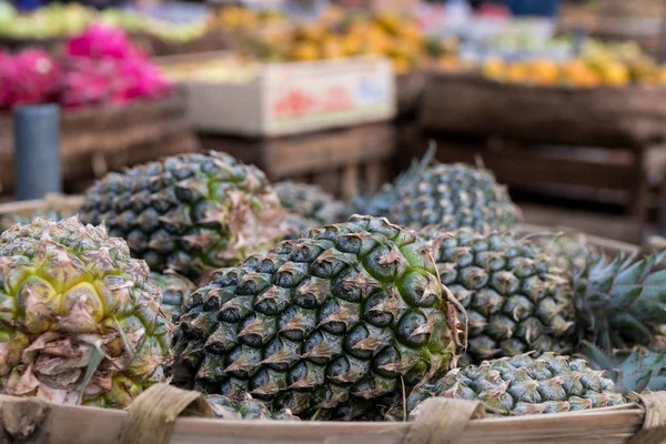 Pile of tropical organic pineapples fruits in basket for sell in tradtional farmer market of Bali island, Indonesia. — Stock Photo, Image
