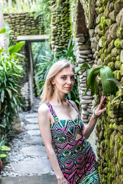 Beautiful slender woman among tropical plants. Beauty, fashion. Spa, healthcare. Tropical vacation. Bali island.