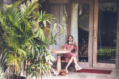 Genç seksi kadın siiting sandalyede onun lüks Villa. Bali Adası.