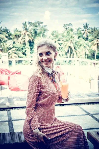 Vrouw met tropische mango sap buitenshuis, café. Bali eiland. — Stockfoto