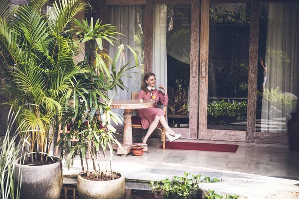 De siiting van de jonge sexy vrouw op stoel op haar luxevilla. Bali eiland. — Stockfoto