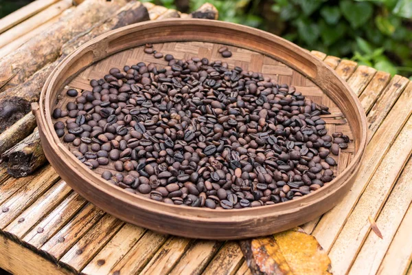 Grãos de café arábica orgânicos torrados. Ilha tropical exótica de Bali, Indonésia. Café bali autêntico em uma plantação de café. Café em um fundo de madeira . — Fotografia de Stock