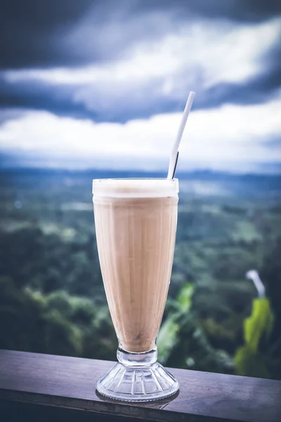 Ice coffee latte in a tall glass on a beautiful nature background. Tropical Bali island, Indonesia. — Stock Photo, Image
