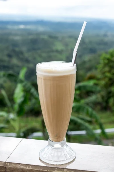 Ледяной кофе латте в высокий стакан на красивом природном фоне. Тропический остров Бали . — стоковое фото