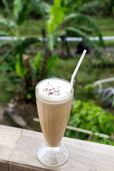 Eiskaffee-Latte in einem hohen Glas vor einem wunderschönen Naturhintergrund. tropische bali-insel, indonesien. — Stockfoto