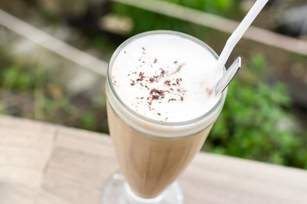 Café con leche helada en un vaso alto sobre un hermoso fondo natural. Isla tropical de Bali, Indonesia . — Foto de Stock