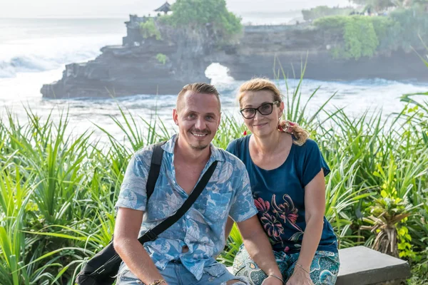 BALI, INDONESIA - 4 MAGGIO 2017: Donna e suo figlio sullo sfondo del tempio di Pura Tanah, isola di Bali, Indonesia . — Foto Stock