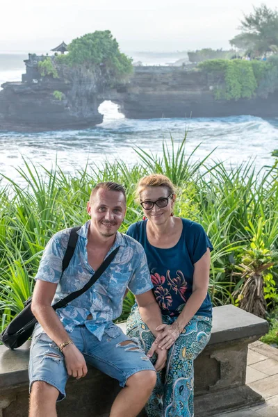 BALI, INDONESIA - 4 MAGGIO 2017: Donna e suo figlio sullo sfondo del tempio di Pura Tanah, isola di Bali, Indonesia . — Foto Stock