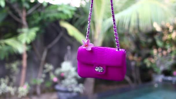 Fashion luxury snakeskin python handbag in motion on a tropical garden background. Bali island. Small pink bag. — Stock Video