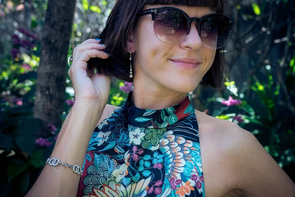 Jovem atraente em um belo vestido de seda entre as plantas tropicais. Férias. Trópicos. Tiro de moda. Ilha de Bali . — Fotografia de Stock