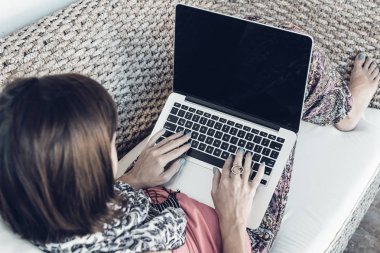 Ahşap Koç açık havada üzerinde dizüstü bilgisayar kullanan bağımsız kadın. Bali Adası, Endonezya.