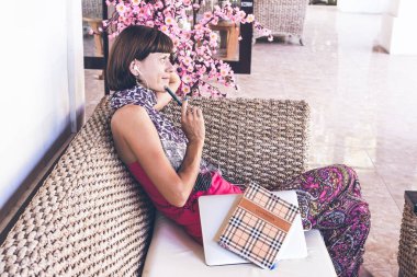 Güzel genç kadın ile defter ve laptop ahşap Koç açık havada, Bali Adası, villa.