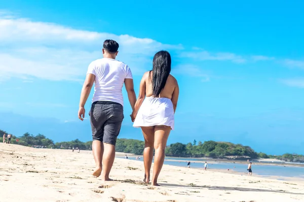 Aziatische paar wandelen op het strand van het tropische eiland Bali, Indonesië. — Stockfoto