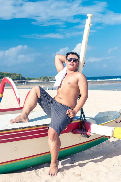 Jeune homme indonésien asiatique relaxant sur la plage de l'île tropicale de Bali, Indonésie . — Photo