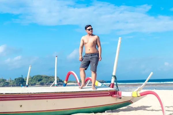 Young asian indonesian man relaxing on the beach of tropical Bali island, Indonesia. — Stock Photo, Image