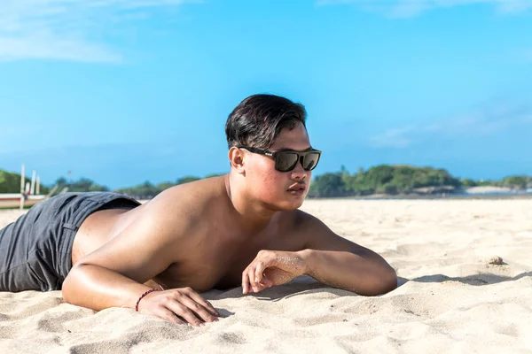 Young asian indonesian man on the beach of tropical Bali island, Indonesia. — Stock Photo, Image