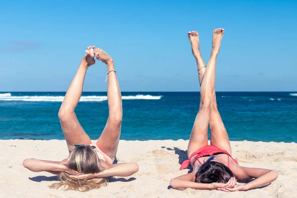 Bali tropikal plaj adada, Nusa Dua, Endonezya güneşlenme iki mutlu seksi kadın arkadaş.