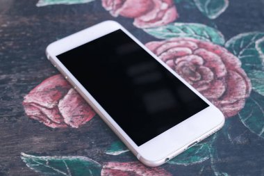 Beyaz cep telefonu kafede vintage masa örtüsü üzerine boş siyah perde ile mockup görüntüsü. Bali Adası.