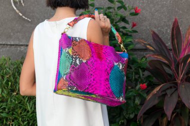 Lüks yılan derisi python çanta tutan kadın. Bali Adası. Moda çanta kavramı tropik bir adada.