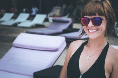 Şezlong üzerinde rahatlatıcı. Güzel genç kadın güneş gözlüğü sahilde şezlong üzerinde rahatlatıcı. Seksi kadın portre.