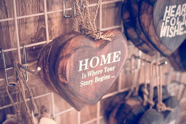 Houten harten op een turkooizen achtergrond voor vintage hout mooi geplaatst. Handgemaakte houten harten met tekst in Souvenirwinkel op Bali eiland, Indonesië. Pastel filter. — Stockfoto