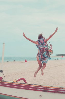 Çekici kız atlamayı Beach sahip eğlenceli, tatil yaz yaşam tarzı tatil. Mutlu kadın özgürlük beyaz kum üzerinde atlama tekneler yakın. Bali Adası.