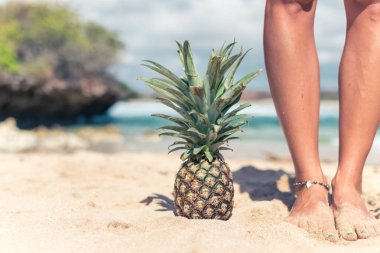 Kadın el okyanus zemin üzerine taze ananas egzotik meyve ile. Taze sağlıklı diyet gıda kavramı. Bali Adası.
