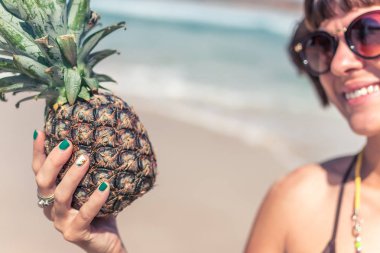 Ananas üzerinde seyir ve gülümseyen kadın tropikal yaz. Açık havada, okyanus, doğa. Bali Adası cennet.
