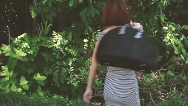 Young woman with luxury snakeskin python bag in nature. Tropical Bali island, Indonesia. Fashion girl outside. — Stock Video