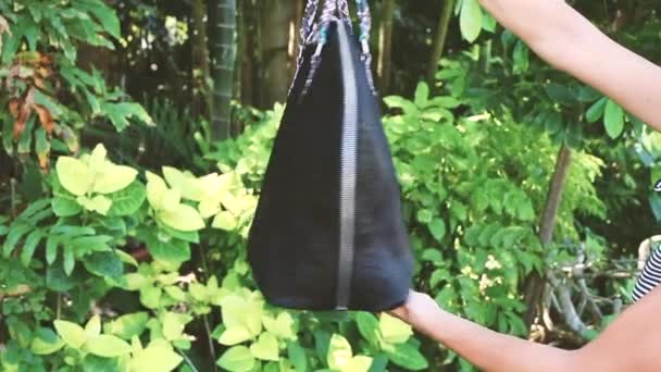 Young woman with luxury snakeskin python bag in nature. Tropical Bali island, Indonesia. Fashion girl outside. — Stock Video