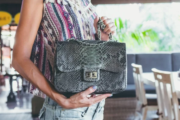 Крупный план женщина руки с модой роскошной змеиной кожи Python сумка. На открытом воздухе, остров Бали . — стоковое фото
