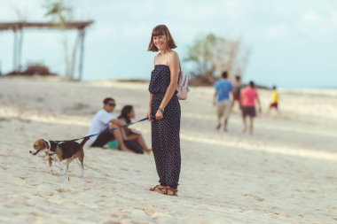 Genç kadın ile onun güzel beagle köpek Bali beach Adası, Endonezya.
