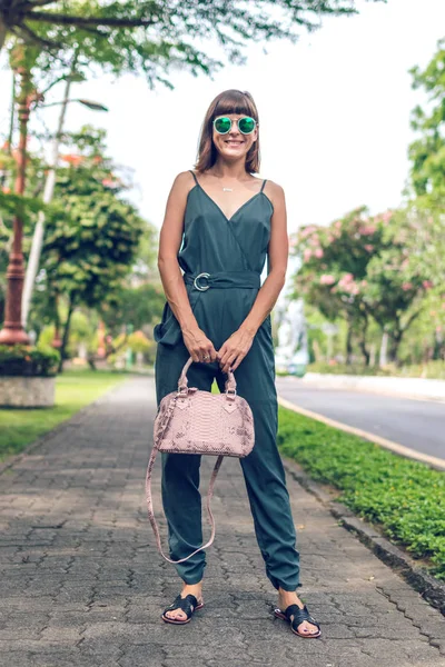 Closeup attractive beautiful woman with snakeskin python handbag posing outdoors. Bali island. — Stock Photo, Image