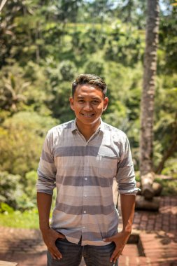 Bali, Endonezya - 5 Aralık 2017: Closeup Asya Bali Endonezya adam ormanda Bali Adası'nın portresi. Asya yakışıklı genç.