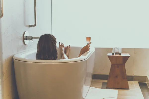 Jonge aantrekkelijke vrouw met champagne glas ontspannen in bad. Sexy vrouw in de badkamer. Vrouwelijke spa. — Stockfoto