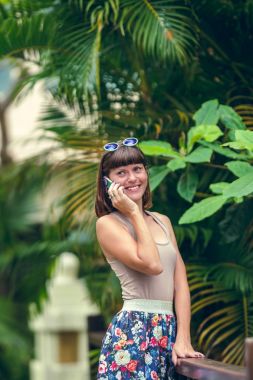 Mutlu çekici genç kadın cep telefonunuzun ve yaz tatil tropikal bir adada Bali, Endonezya.