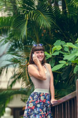 Mutlu çekici genç kadın cep telefonunuzun ve yaz tatil tropikal bir adada Bali, Endonezya.