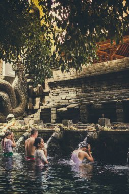 Bali, Endonezya - 5 Aralık 2017: Kutsal kaynak suyu. Tirta Empul tapınakta dua insanlar. Bali, Endonezya.