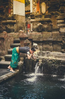 Bali, Endonezya - 5 Aralık 2017: Kutsal kaynak suyu. Tirta Empul tapınakta dua insanlar. Bali, Endonezya.
