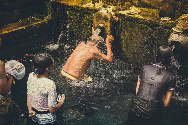 Bali, Endonezya - 5 Aralık 2017: Kutsal kaynak suyu. Tirta Empul tapınakta dua insanlar. Bali, Endonezya.