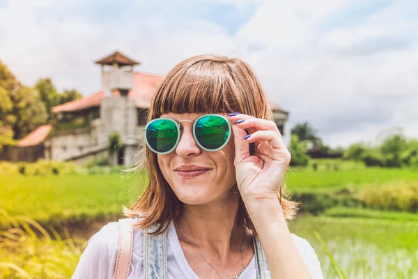 Utomhus mode porträtt av ung vacker dam solglasögon, sommaren koncept. Risfält på en bakgrund. Tropisk ö i Bali, Indonesien. — Stockfoto