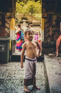 Bali, Endonezya - 5 Aralık 2017: Portre sevimli Asya Balili çocuk açık havada tapınağında portresi. Ubud alan, Bali Adası, kız gülümseyerek.